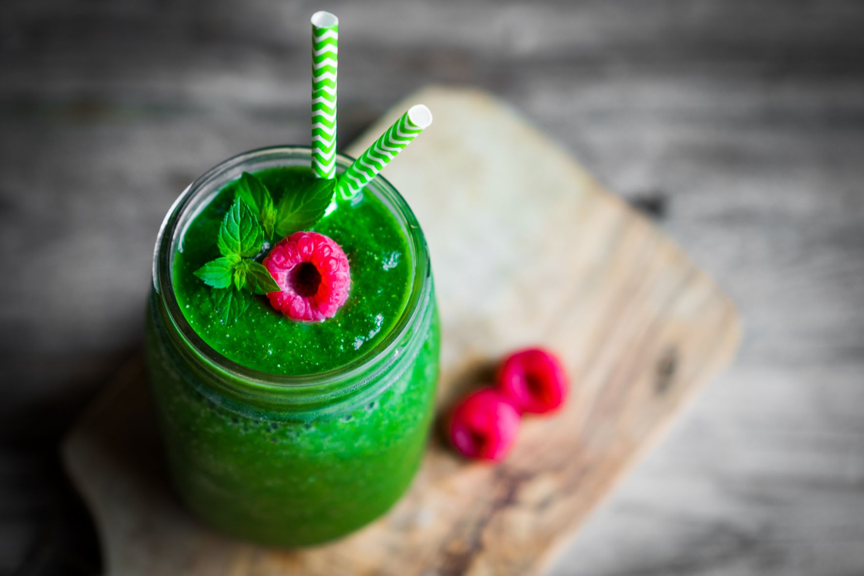 Fresh green smoothie on rustic wooden background
